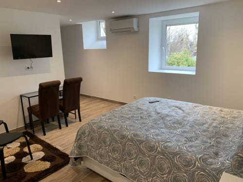 Chambre moderne au B&B Le Restaurant du Port à Saint Pierre de Boeuf avec lit, TV, vue sur le jardin et coin repas
