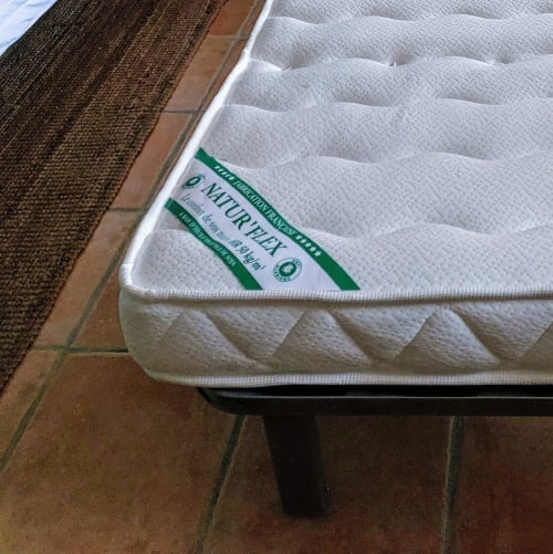 Close-up of a white quilted mattress with green Naturezzy label in a cottage bedroom at Les Gites de Campardon, Monties,