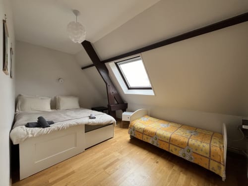 Chambre mansardée lumineuse au Domaine du Verger en Auge avec lits jumeaux, parquet, velux et poutre apparente