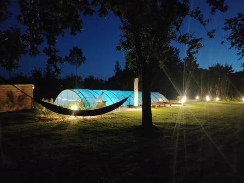 Serre et piscine illuminées la nuit, gîte Le Domaine du Verger en Auge en Normandie, France