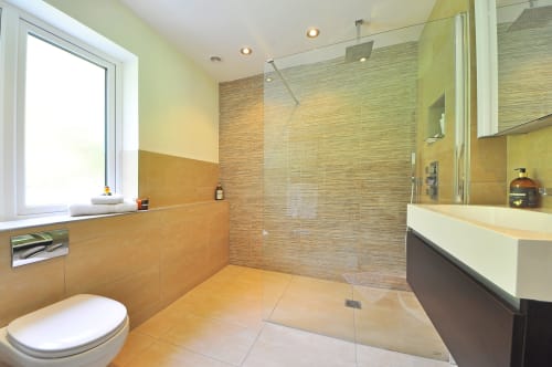 Baño moderno del Hotel Santorini Belgrade con ducha abierta, doble tocador y tonos tierra cálidos