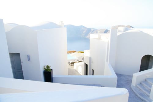 Arquitectura encalada del Hotel Santorini Belgrade con terraza con vistas a agua azul tipo caldera