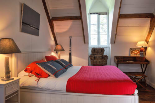 Chambre cosy sous les toits avec literie rouge, poutres apparentes et vue sur le jardin au Petit Manoir de Kériolet, Concarneau