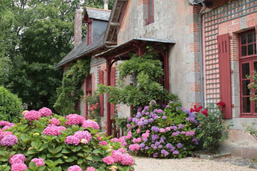 Les hortensias roses et violets encadrent l'entrée de charme du Petit Manoir de Kériolet à Concarneau