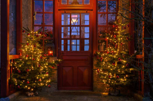 Entrée à la porte rouge du Petit Manoir de Kériolet décorée de sapins de Noël illuminés et d'ornements, Concarneau