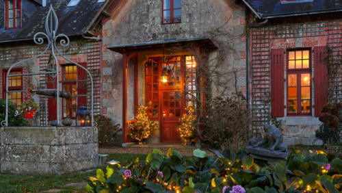 Le Petit Manoir de Kériolet à Concarneau : charmante demeure en pierre aux volets rouges, lumières accueillantes et ambiance festive