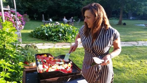 Femme préparant des légumes au grill dans le jardin du Petit Manoir de Kériolet à Concarneau, France