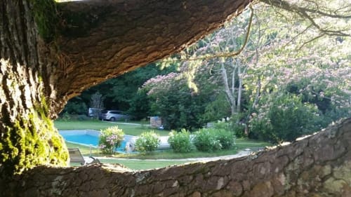 Vue à travers une voûte en pierre de la piscine et du jardin du Petit Manoir de Kériolet à Concarneau, France