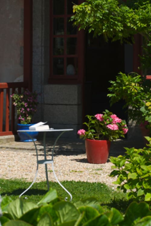 Cour fleurie du Petit Manoir de Kériolet avec table de bistrot à Concarneau