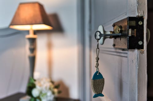 Clé vintage sur la serrure de la porte du Petit Manoir de Kériolet, Concarneau, avec lumière chaude de lampe en arrière-plan