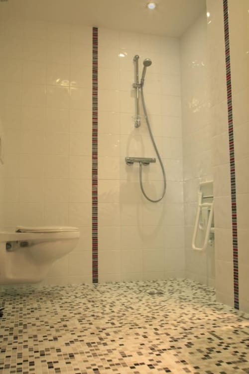 Modern wheelchair accessible shower in ZEPHYR room at Maison Addama B&B, Neyron with decorative tile accents