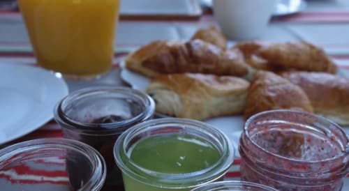 Continental breakfast spread at Maison Addama B&B in Neyron with pastries, croissants, jams, and orange juice