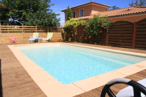 Maison Addama pool area in Neyron with loungers, wooden deck, and terracotta villa