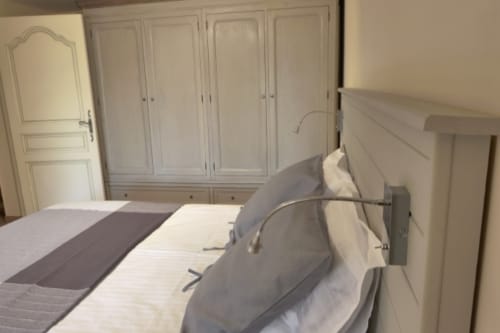 Elegant bedroom with white wardrobe and bed at Villa Thébaïde B&B in Laudun L'Ardoise, France