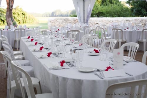 Elegant outdoor dining setup at Domaine de Lamartine with white-dressed tables, red napkins, and countryside views in