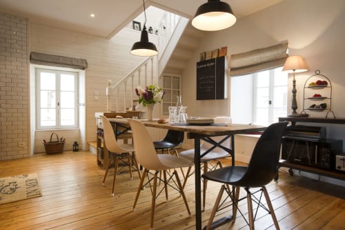 Modern cottage eetgedeelte met houten tafel, designstoelen, dakraam en zeezicht bij Les Filles du Bord de Mer