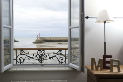 Ocean view from Les Filles du Bord de Mer hotel room with balcony overlooking Port-en-Bessin harbor
