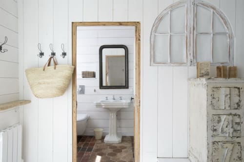 Rustic bathroom at Les Filles du Bord de Mer hotel in Port-en-Bessin with pedestal sink and vintage décor