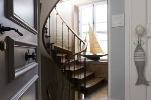 Elegant spiral staircase with metal railing at Les Filles du Bord de Mer hotel in Port-en-Bessin, Normandy