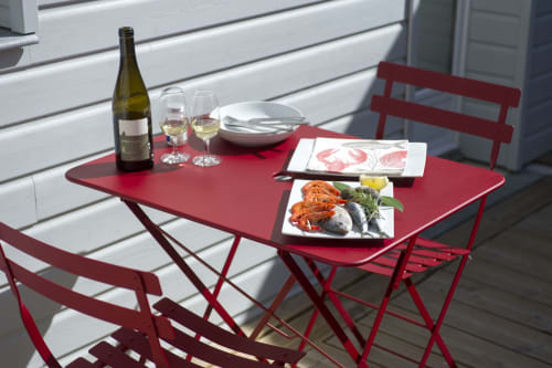 Table de bistrot rouge dressée avec vin et fruits de mer aux Filles du Bord de Mer, Port-en-Bessin