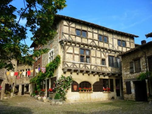 Maison Addama B&B in Neyron, France - Medieval half-timbered building with stone courtyard and flower decorations