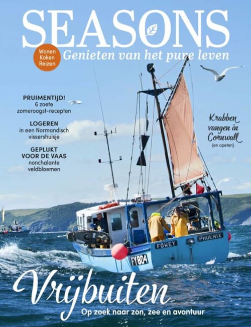 Traditionelles Fischerboot mit beigen Segeln im Hafen von Port-en-Bessin an der Normandieküste