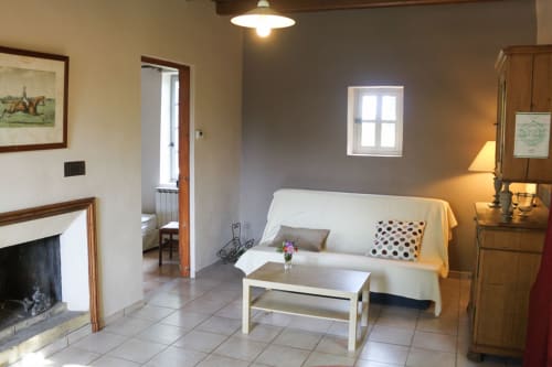 Salon confortable du Domaine de Lamartine B&B à Pont-Saint-Esprit avec canapé blanc, cheminée et meubles en bois