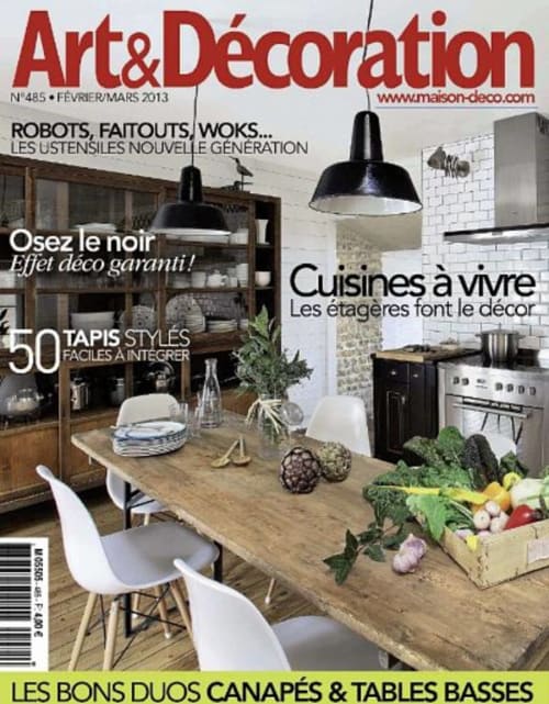 Titelbild des Magazins Art & Décoration mit modernem Küchen- und Essbereichdesign mit schwarzen Pendelleuchten und Holztisch