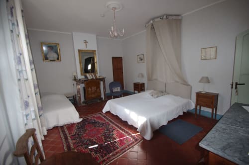 Spacious bedroom at Domaine de Lamartine with bed, fireplace, and period furnishings in Pont-Saint-Esprit