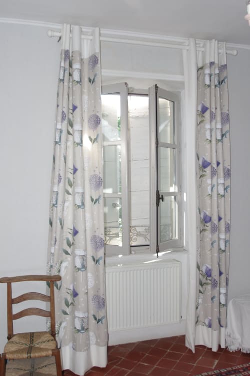French doors with purple floral curtains opening to garden view at Domaine de Lamartine, Pont-Saint-Esprit