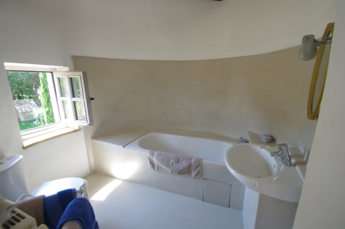 Bright bathroom with bathtub, sink, and window view at Domaine de Lamartine, Pont-Saint-Esprit