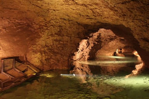 Underground cave pool at Maison Addama BnB in Neyron, France with illuminated red rock formations