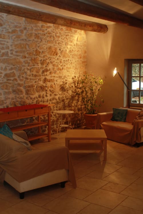 Cozy cottage living area at Domaine de Lamartine with stone walls, wooden beams, and rustic furnishings in Pont-Saint-Esprit