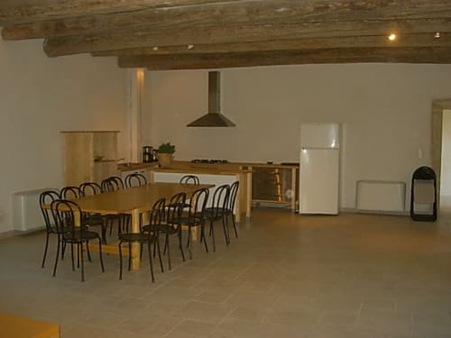 Spacious dining and kitchen area in La bergerie cottage at Domaine de Lamartine with wooden beams, dining table, and modern