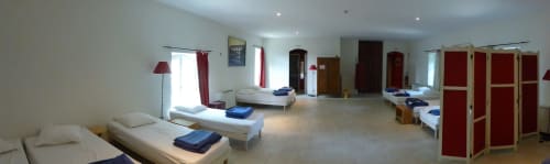 Bright dormitory-style room at Domaine de Lamartine with multiple beds, red wardrobe, and garden view in Pont-Saint-Esprit