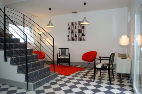 Hall moderne du Domaine de La Serita B&B à Joze, France, avec mobilier rouge, sols à carreaux et escalier