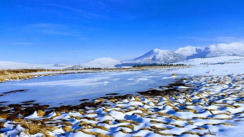 Paysage enneigé avec lac gelé et montagne enneigée au Domaine de La Serita, Jozé France
