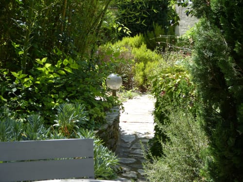 Üppiger Gartenweg der Villa Thébaïde mit grünen Hecken und steinerner Arkade führend zum Innenhof in Laudun L'Ardoise