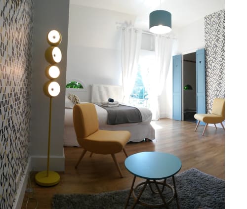 Chambre vintage de la villa Domaine de La Serita avec mobilier années 50, table bleue, lampadaire laiton et vue sur piscine à Joze