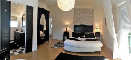 Chambre de la villa Blanca Nera au Domaine de La Serita à Joze, France avec mobilier noir, linge de lit blanc et équipements modernes