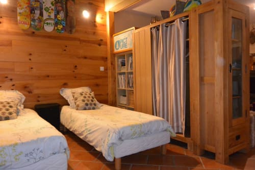 Chambre cosy en bois à la gîte Aux Pays Des Sucs avec lits jumeaux, armoire et rideaux rayés