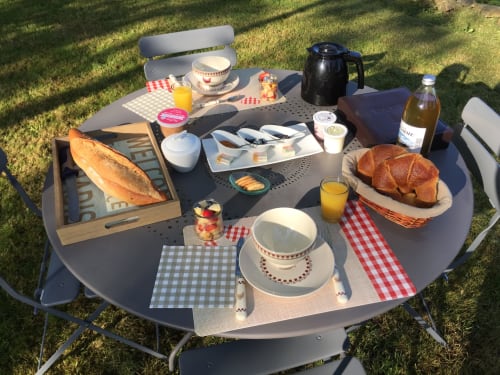 Petit-déjeuner en plein air aux Pays Des Sucs à Saint-Hostien avec viennoiseries, pain, jus et café servis dans le jardin