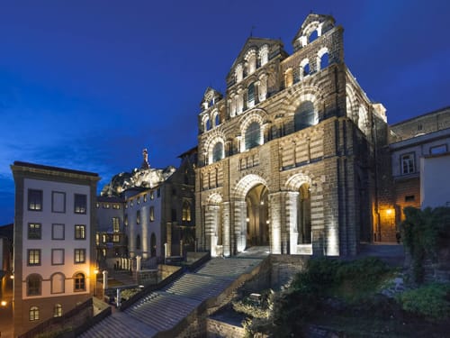 Église en pierre historique illuminée au crépuscule à Saint-Hostien, France, près du gîte Aux Pays Des Sucs