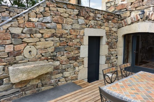 Terrasse en pierre aux Pays Des Sucs avec foyer rustique et coin détente