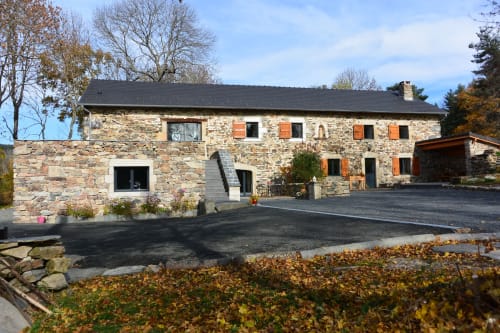 Gîte en pierre Aux Pays Des Sucs à Saint-Hostien, toit sombre, volets orange, allée et jardins automnal