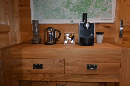 Commode en bois avec cafetière, bouilloire et commodités à l'Aux Pays Des Sucs B&B à Saint-Hostien