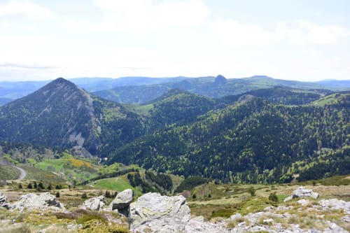 Vue panoramique du paysage montagneux aux Pays des Sucs, Saint-Hostien, avec vallées boisées et pics ondulants