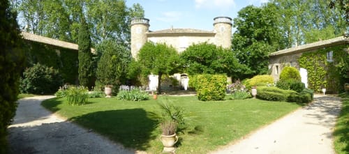 Domaine de Lamartine gardens with ivy-covered stone mansion, manicured lawns and topiary in Pont-Saint-Esprit