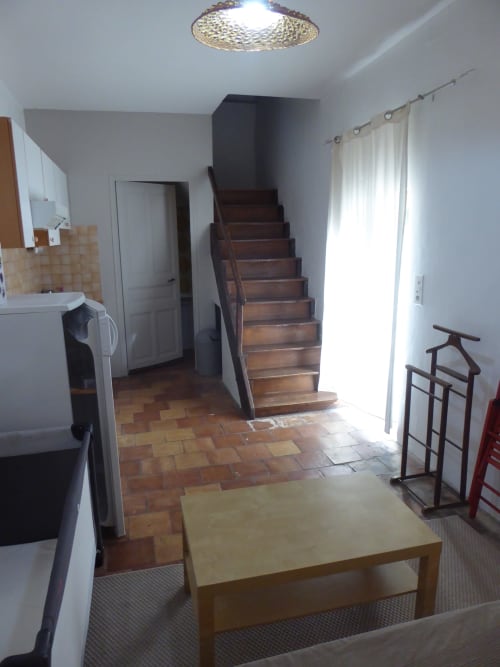 Ramona cottage at Domaine de Lamartine showing open-plan living area with wooden stairs, kitchen, and garden view in
