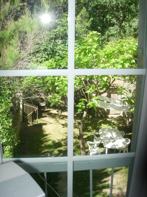 Garden view from Ramona cottage at Domaine de Lamartine in Pont-Saint-Esprit with lush greenery and patio seating